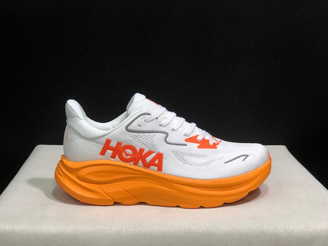 White and Orange HOKA Clifton 10 Running Shoes - product image from the listing.