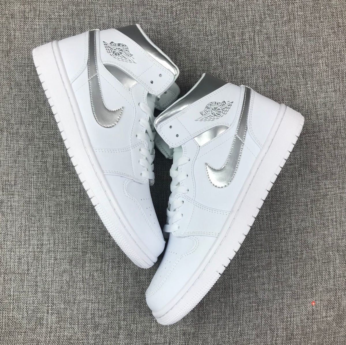 Air Jordan 1 Mid Sneakers in White Silver 554724-105 - product image from the listing.