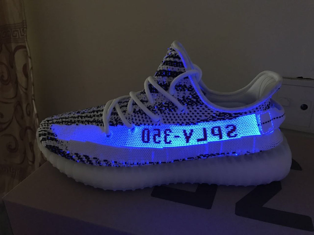 Yeezy 350 V2 Glow-in-the-Dark Sneakers, in Black and White - product image from the listing.