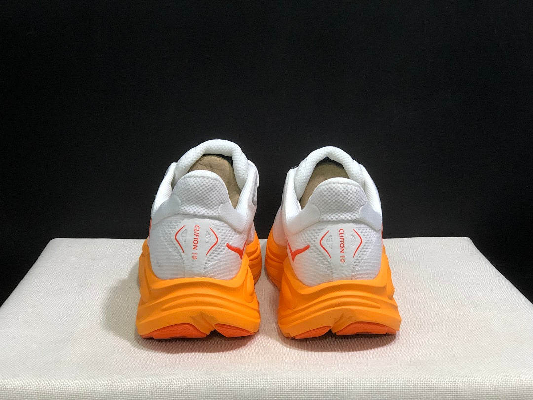 White and Orange HOKA Clifton 10 Running Shoes - product image from the listing.