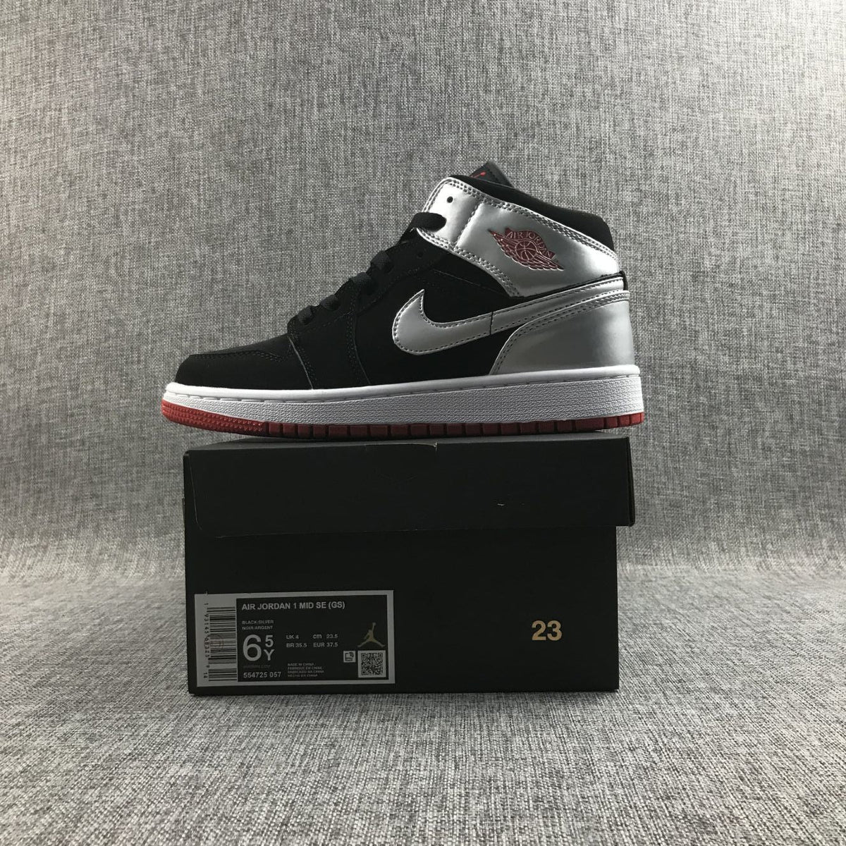 Air Jordan 1 Mid SE GS Sneakers in Black Silver 554725-057 - product image from the listing.