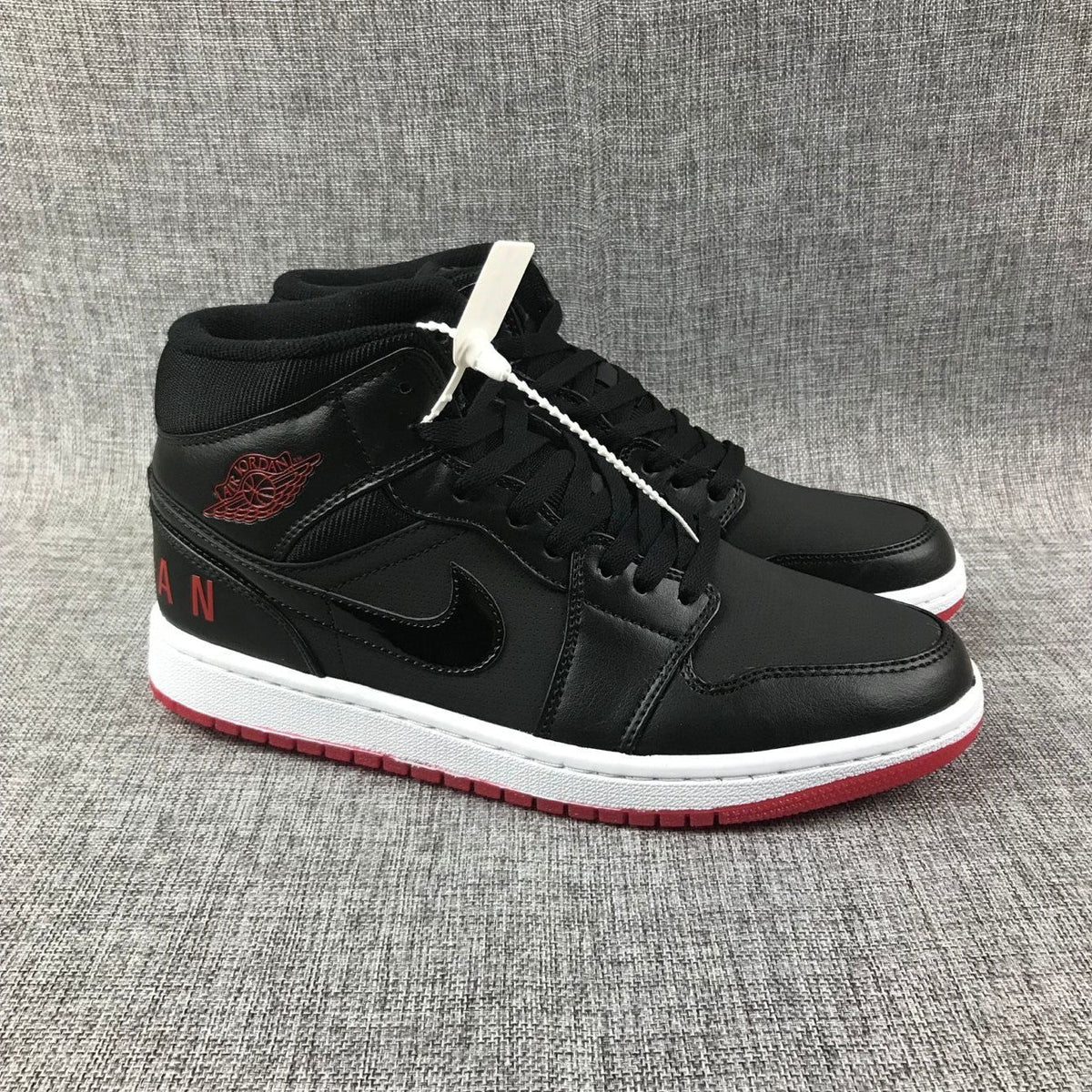 Air Jordan 1 Mid High-Top Sneakers in Black Red White - product image from the listing.