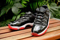 Air Jordan 11 Retro Low Black and Red Sneakers - product image from the listing.
