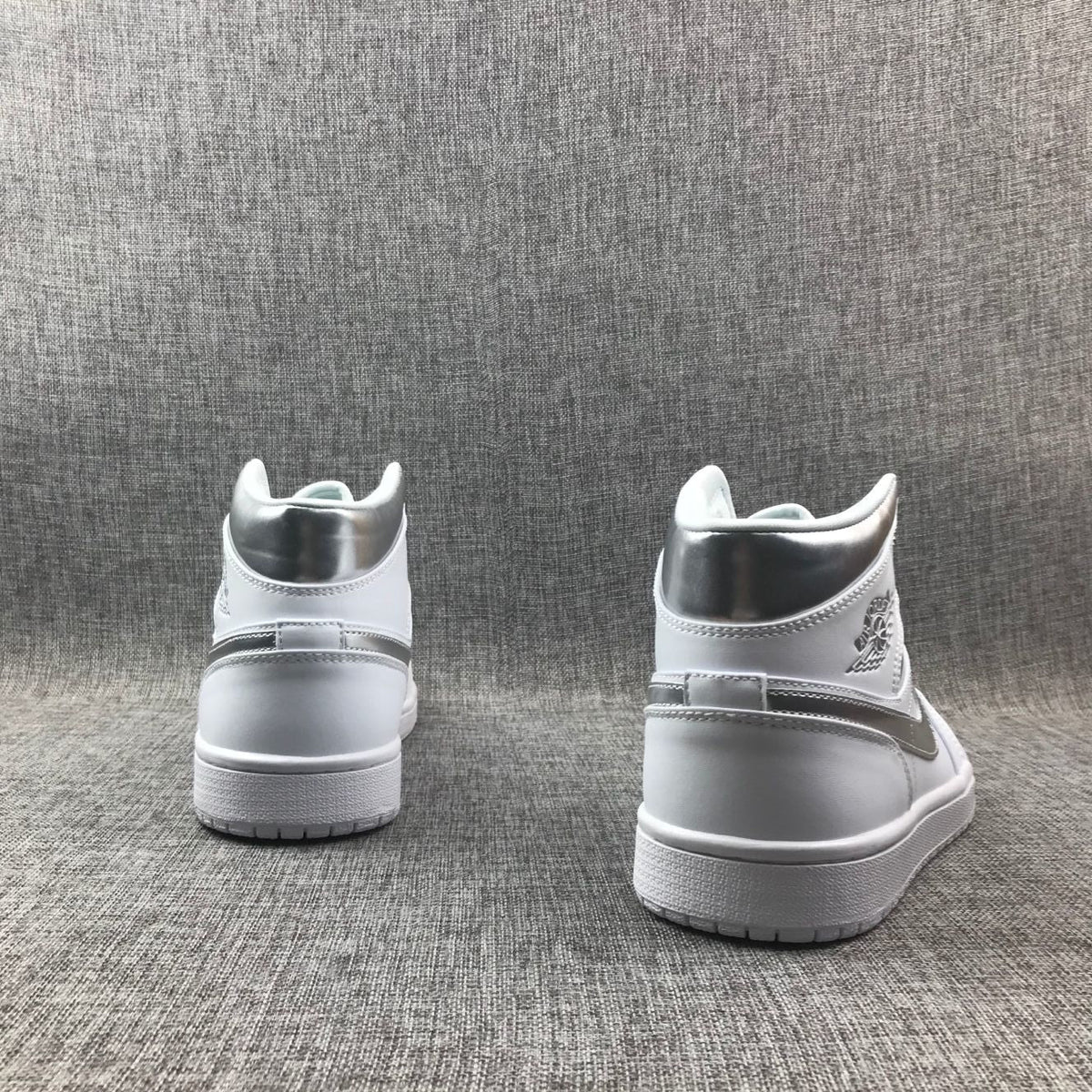 Air Jordan 1 Mid Sneakers in White Silver 554724-105 - product image from the listing.