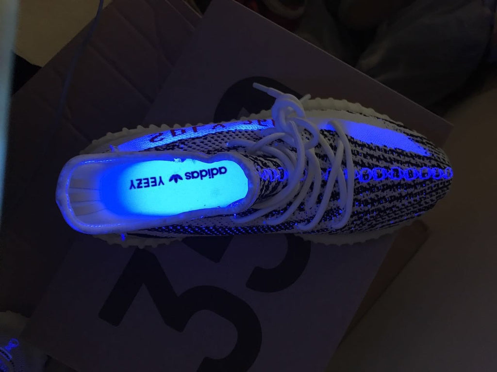 Yeezy 350 V2 Glow-in-the-Dark Sneakers, in Black and White - product image from the listing.