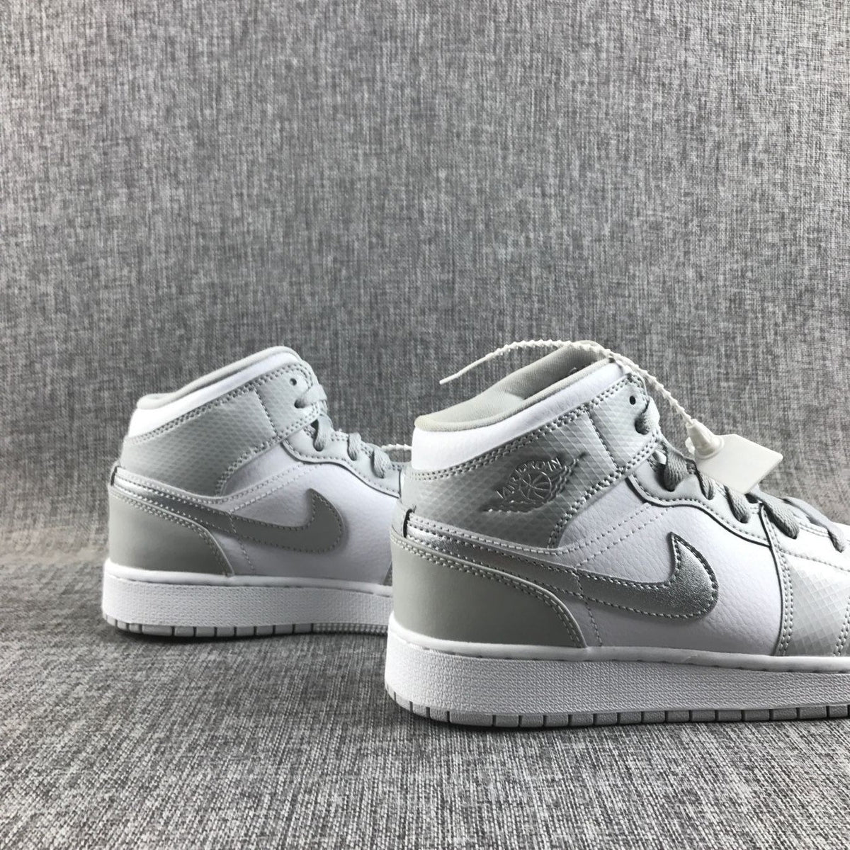 Air Jordan 1 Mid GS White and Silver Sneakers - product image from the listing.