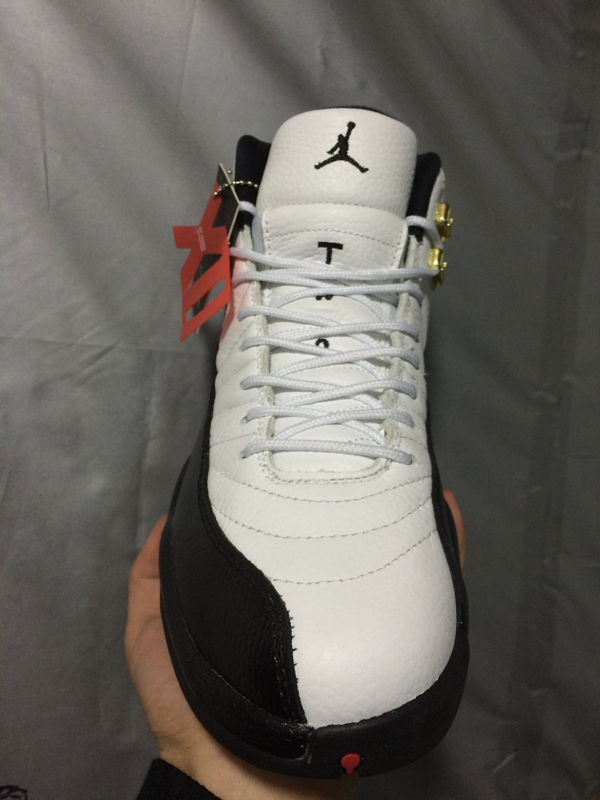 Air Jordan 12 Retro White and Black High-Top Sneakers - product image from the listing.