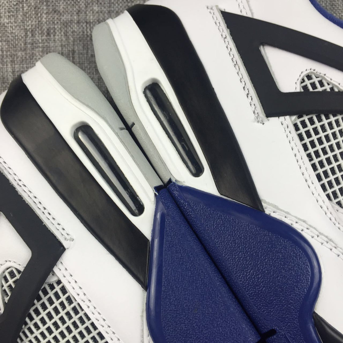 Air Jordan 4 Sneakers in White, Black and Blue - product image from the listing.