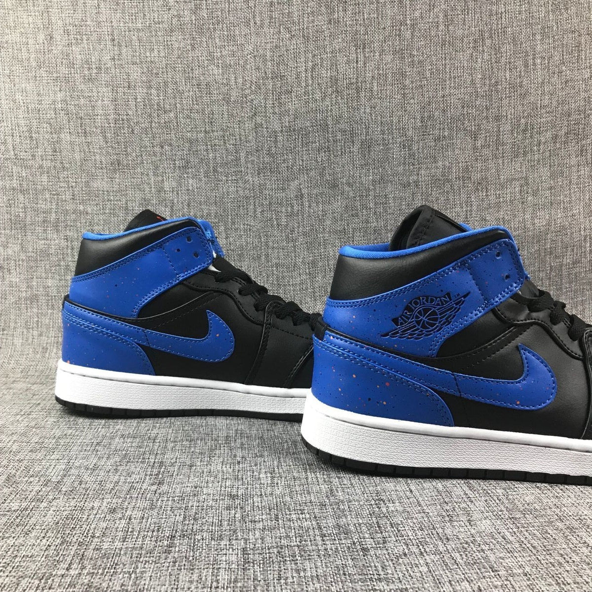 Air Jordan 1 Mid High-Top Sneakers in Black and Blue - product image from the listing.