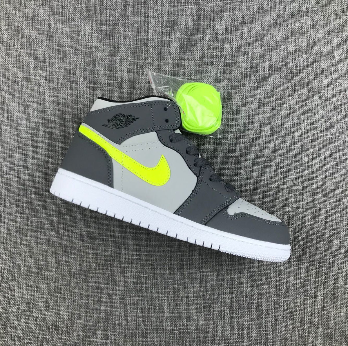 Air Jordan 1 Mid Sneakers in Grey Volt 554724-072 - product image from the listing.