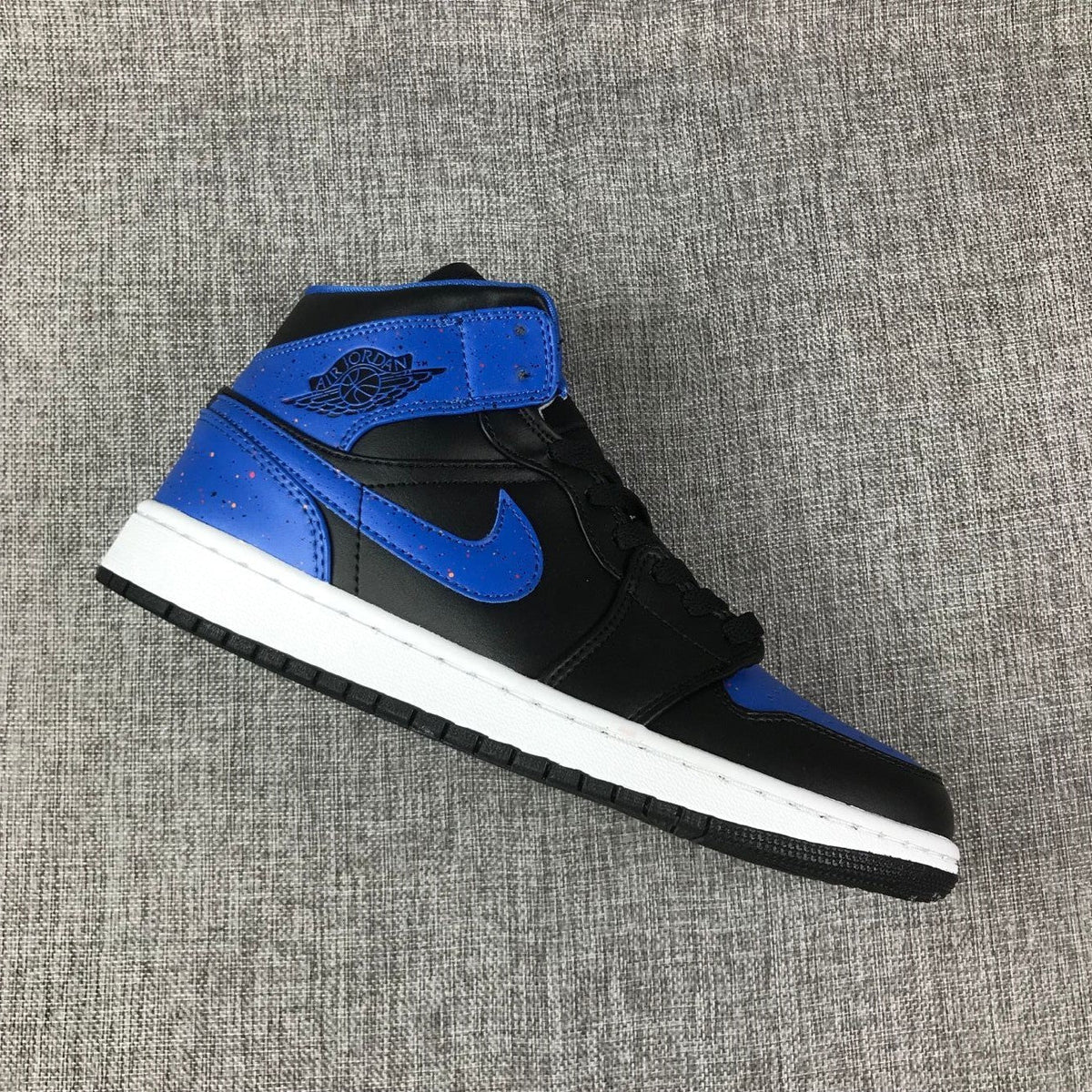 Air Jordan 1 Mid High-Top Sneakers in Black and Blue - product image from the listing.