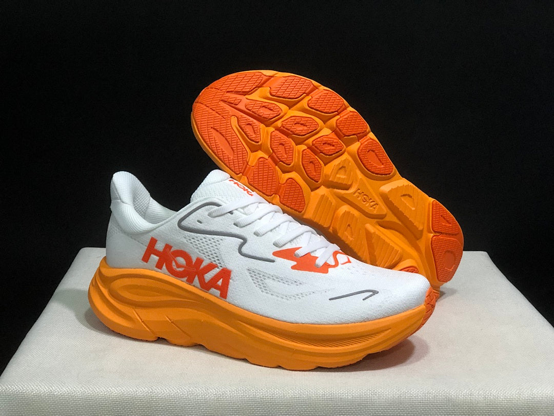White and Orange HOKA Clifton 10 Running Shoes - product image from the listing.