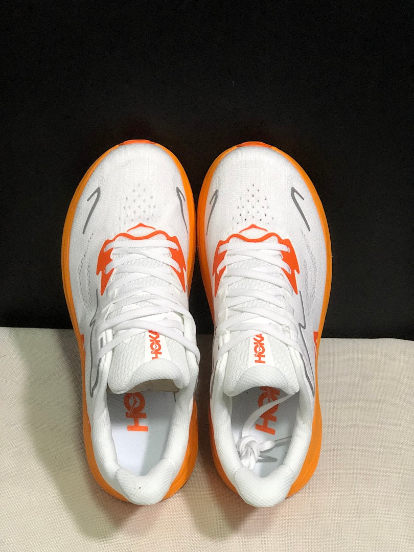White and Orange HOKA Clifton 10 Running Shoes - product image from the listing.