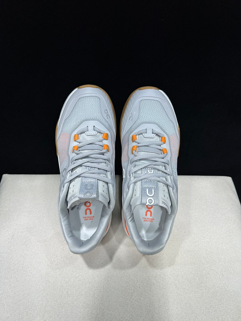 On THE ROGER Advantage Pro Tennis Shoes, in Grey and Orange - product image from the listing.