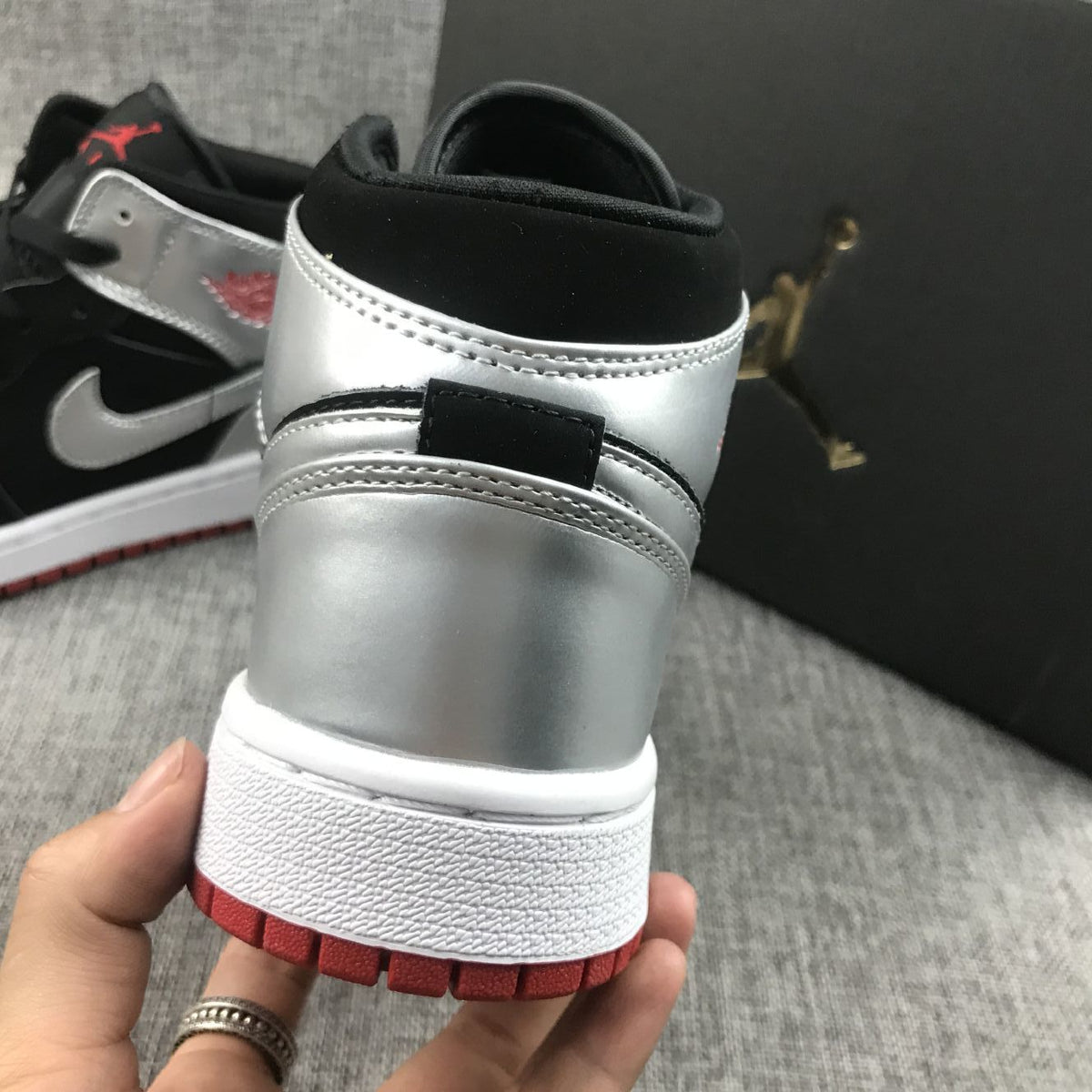 Air Jordan 1 Mid SE GS Sneakers in Black Silver 554725-057 - product image from the listing.