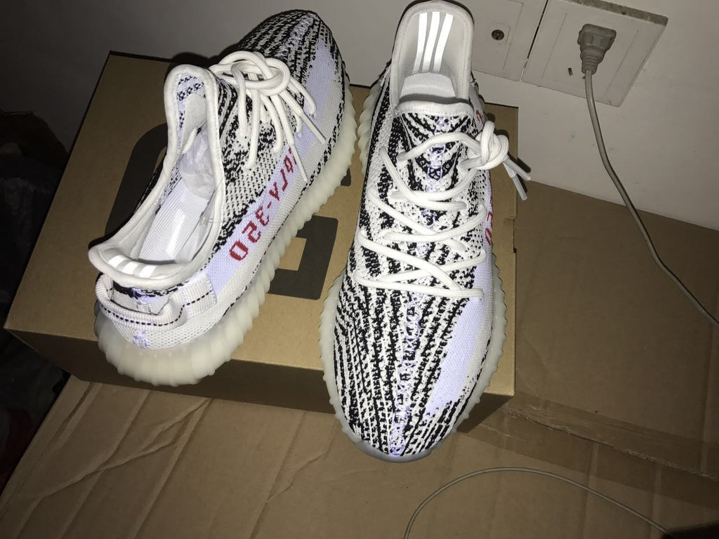 Yeezy 350 V2 Glow-in-the-Dark Sneakers, in Black and White - product image from the listing.