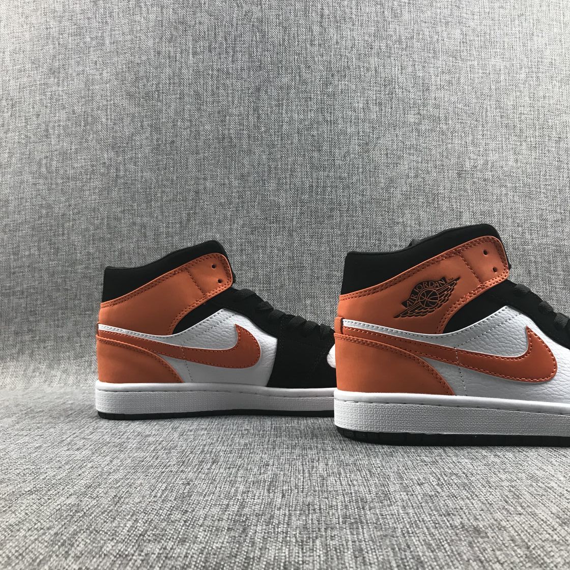 Air Jordan 1 Mid Sneakers in Black White Orange 554724-058 - product image from the listing.