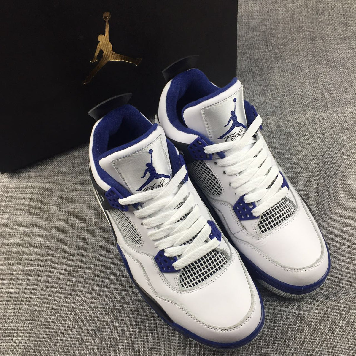 Air Jordan 4 Sneakers in White, Black and Blue - product image from the listing.
