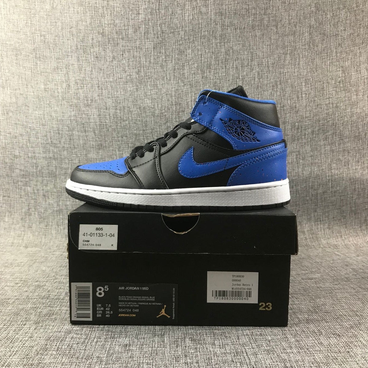 Air Jordan 1 Mid High-Top Sneakers in Black and Blue - product image from the listing.