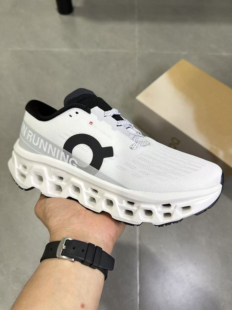 On Running Running Shoes in White and Black - product image from the listing.